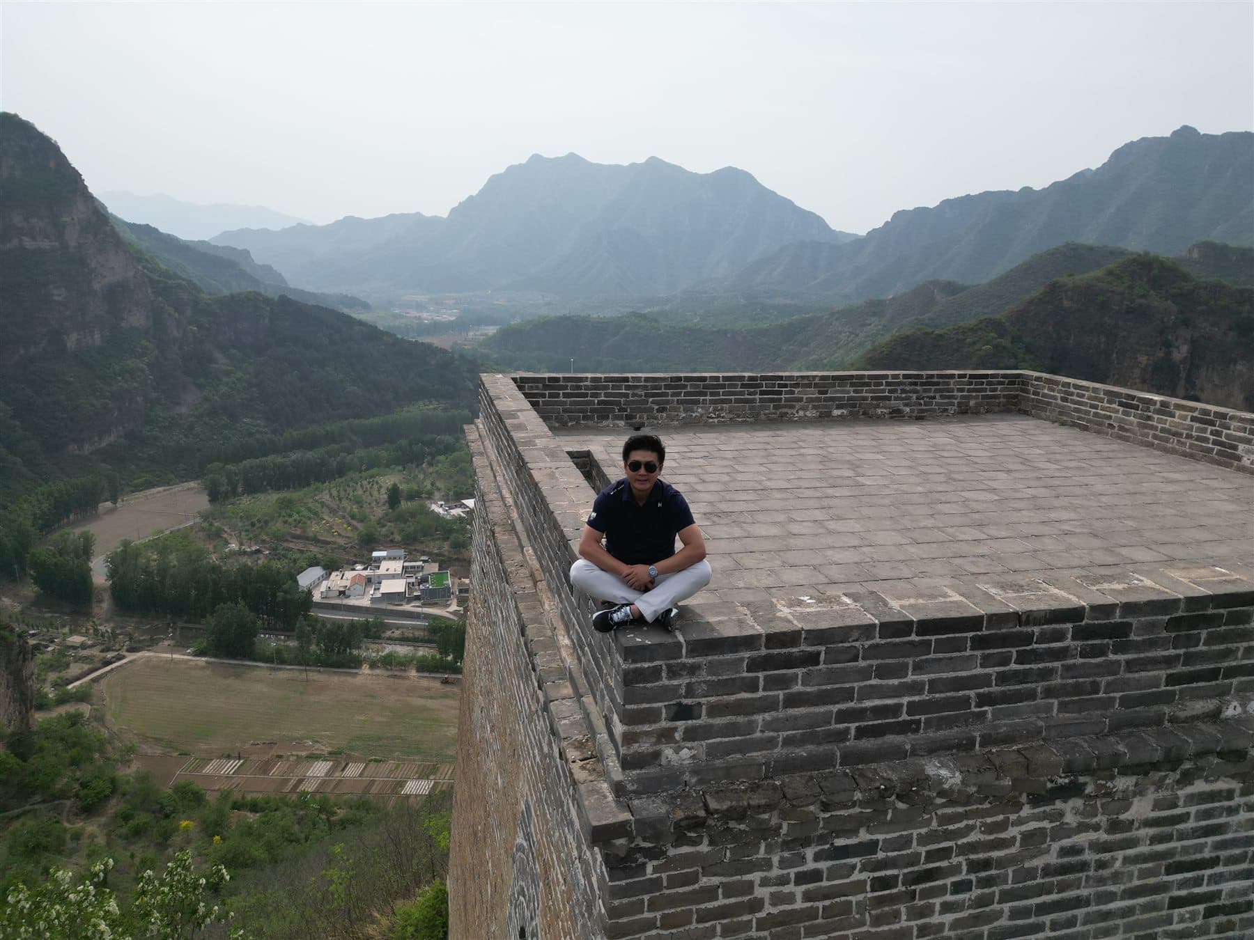 Portrait on a Great Wall watchtower with mountain view